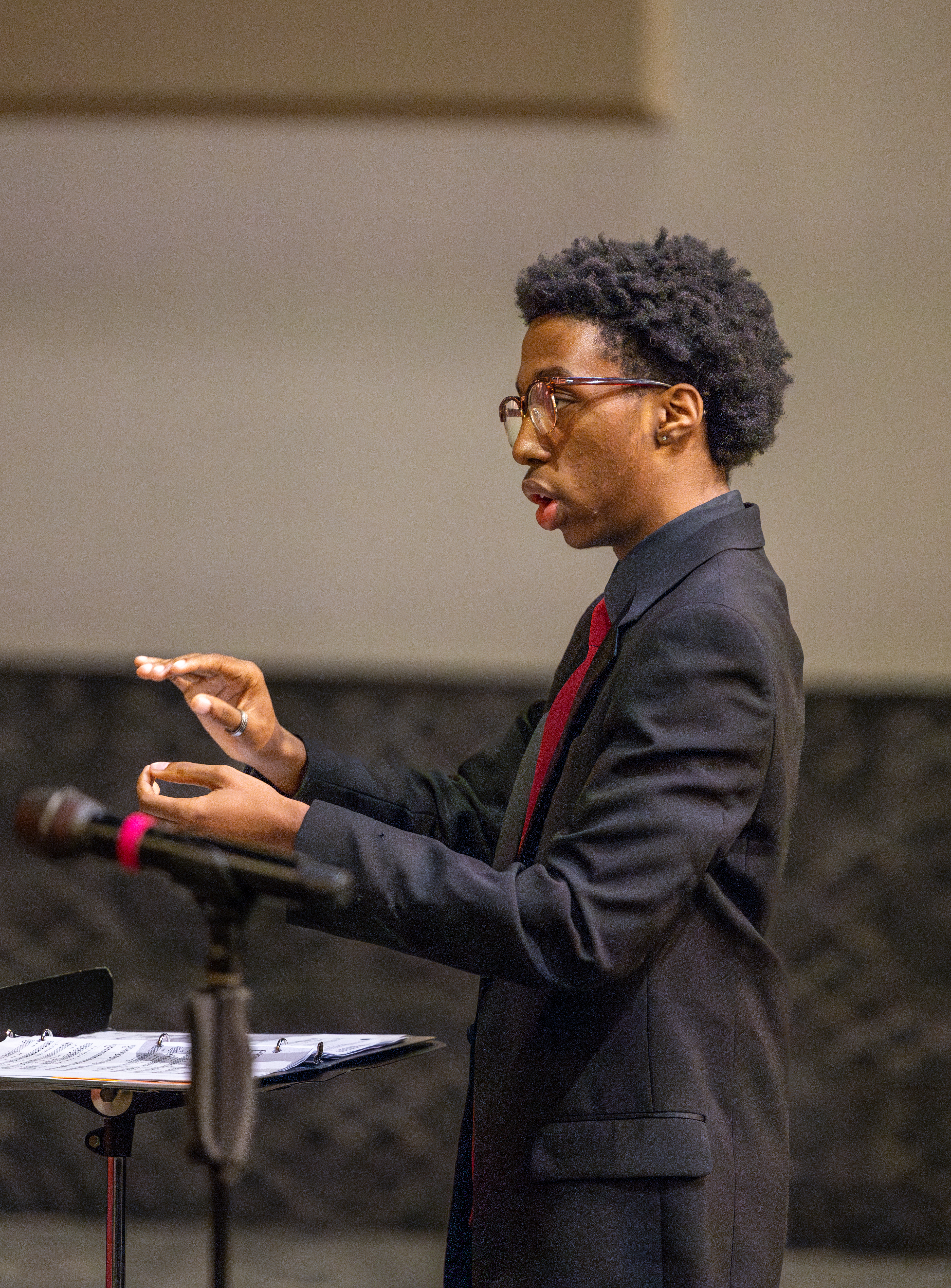 Choir performing on stage with conductor directing