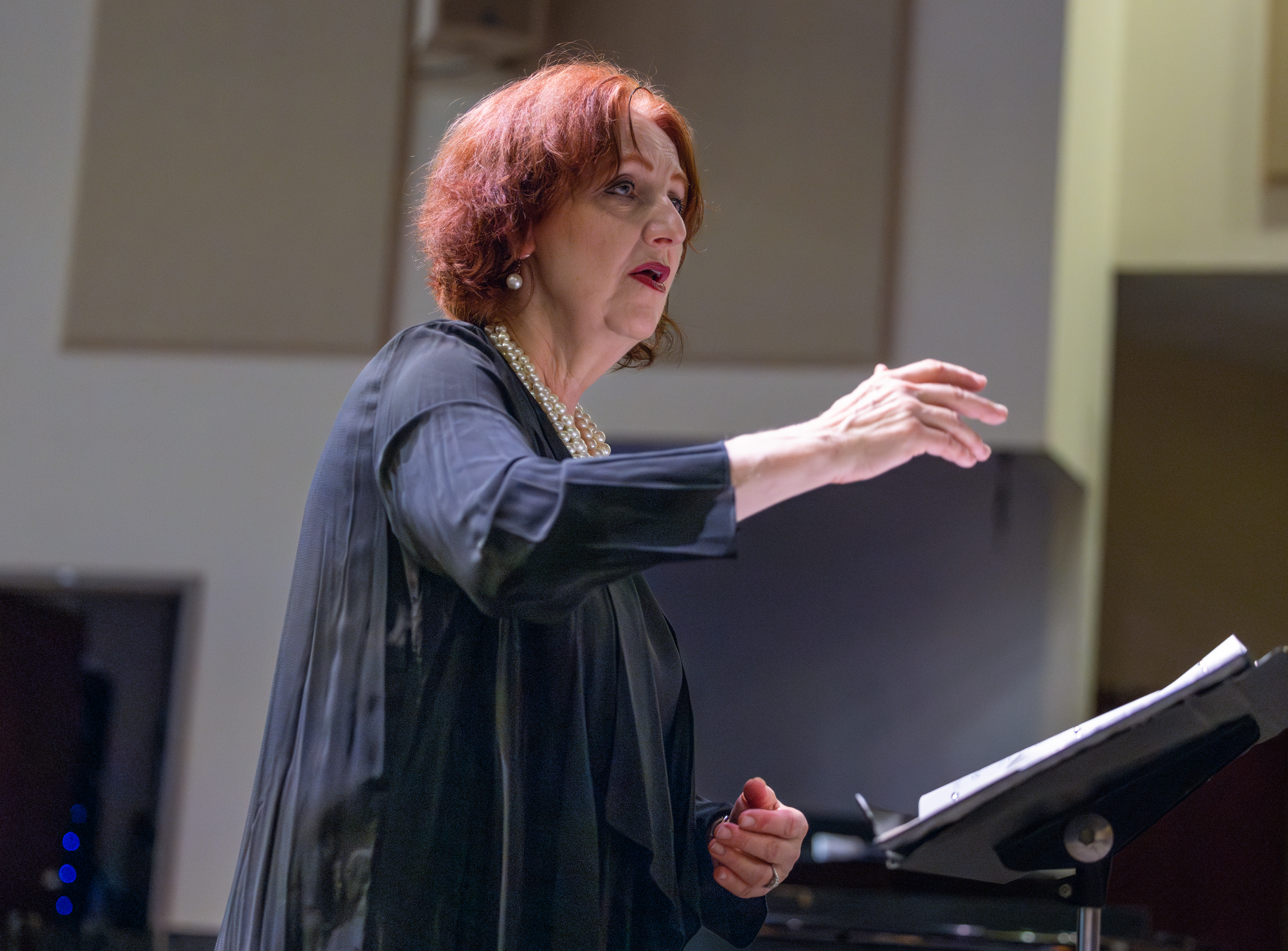 Choir performing on stage with conductor directing